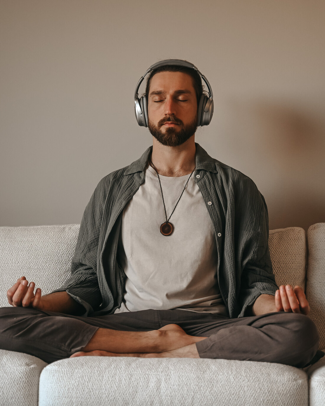 Yogi Igor sitzt mit Kopfhörern in entspannter Meditation